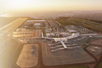 Aerial view of an airport terminal with multiple aircraft parked at gates and on surrounding tarmacs.