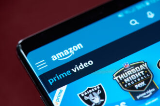 Close-up of the Amazon Prime Video app displayed on a smartphone screen, showing the Amazon logo, Prime Video branding and featured sports content on the home page.