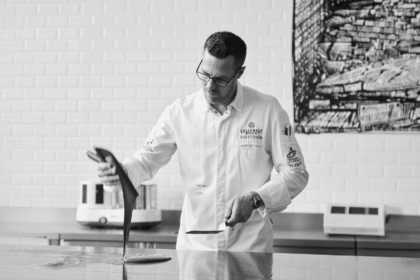 Ryan Stevenson works with chocolate on a marble bench in a Callebaut kitchen.