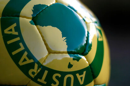 Close-up of a green and gold football featuring a map of Australia.