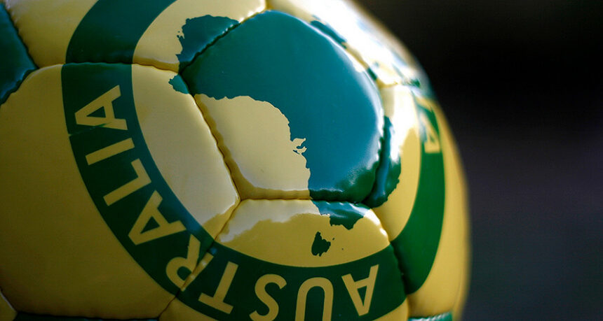 Close-up of a green and gold football featuring a map of Australia.