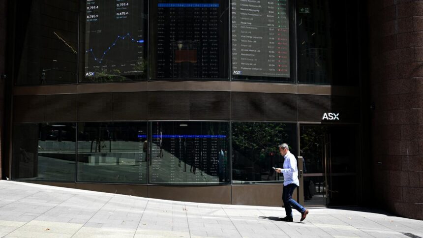Exterior of the Australian Securities Exchange (ASX) building in Sydney, with stock market data displayed on digital screens and a pedestrian walking past the entrance.