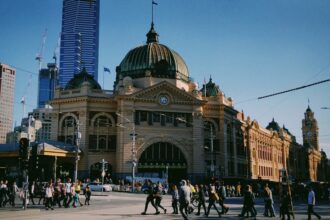 People crossing the road outside busy Flinders Street Station, Melbourne.
